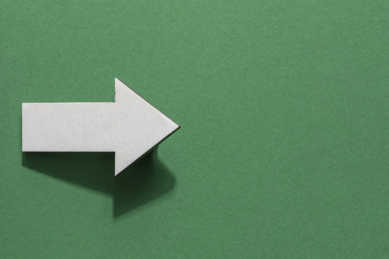 A white arrow on a green background signifying setting the stage for discussing politics in the workplace.